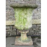 A large weathered cast composition stone campana shaped garden urn with flared egg and dart rim,