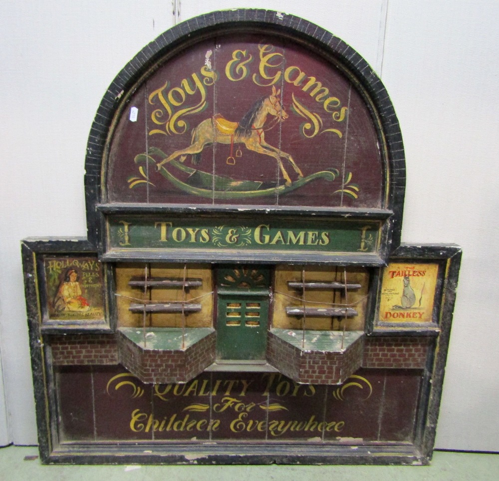 A painted vintage wooden wall mounted sign board of rectangular stepped arched form with toy shop