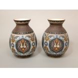 A pair of German Mettlach vases with moulded and painted scrolling and flower head detail, with