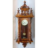 An architectural cased Vienna style wall clock, the enamel dial with Roman numerals and twin train
