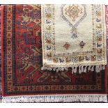 Belgian Shiraz wool rug, with various medallions upon a red ground, 200 x 130cm; together with a