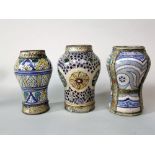 A group of three Persian type vases of shouldered form, with polychrome painted stylised floral