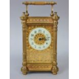 A brass architectural cased carriage clock with gilt fretwork dial and enamelled chapter ring with