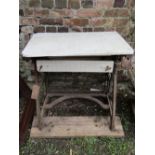 A two to three seat garden bench with slatted seat raised on decorative cast iron ends and