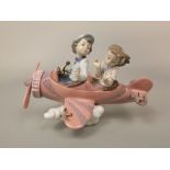 A Lladro Daisa model of two children flying in an airplane with birds on the wing and tail, 24cm