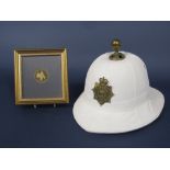 A Royal Marines white pith helmet with applied brass insignia, together with a framed medallion