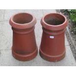 A pair of reclaimed terracotta chimney pots of tapered and banded form, 46 cm high and ironwork