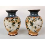 A pair of Royal Doulton vases with moulded leaf and white blossom decoration on a buff coloured