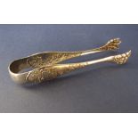 Fine quality pair of continental white metal sugar tongs, with claw pincers and embossed rococo