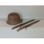 A WWII German military helmet together with two WWI German bayonets by Mauser Flischtel and Sachs,