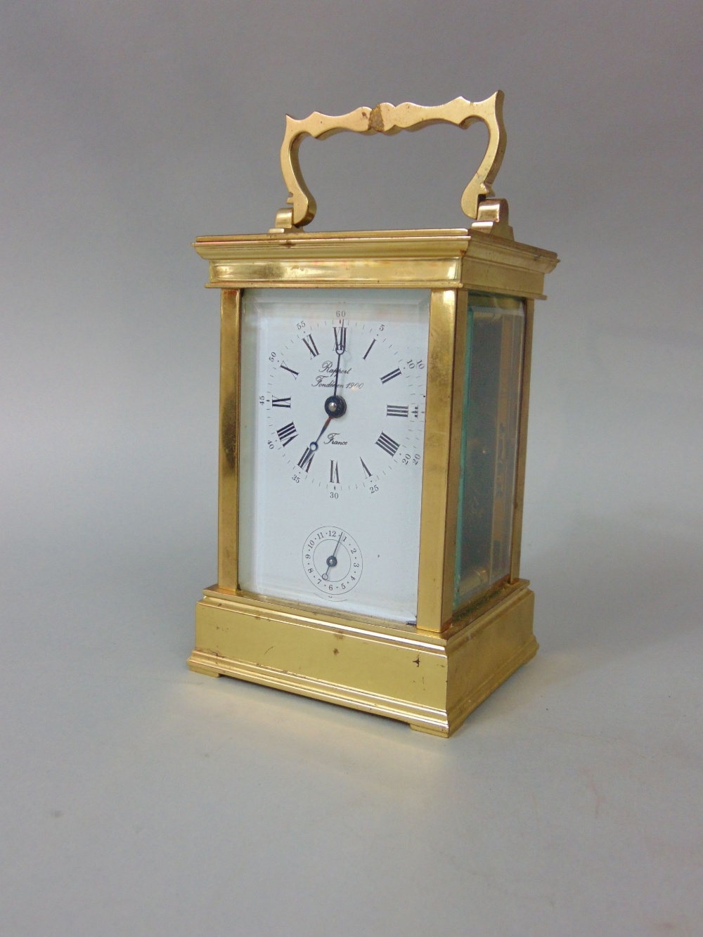 A brass cased carriage clock, the enamelled dial with Roman numerals and subsidiary second dial,