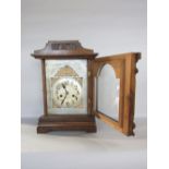Oak twin train mantel clock, with architectural case and silvered dial, 39 cm high