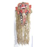 A Taiwanese carved theatrical mask in the form of a grotesque creature with long sisal hair