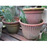 Four weathered contemporary terracotta planters of varying design, one with fluted detail,