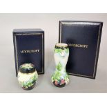 A boxed Moorcroft enamelled vase of waisted form with clematis type floral detail, 10cm tall,