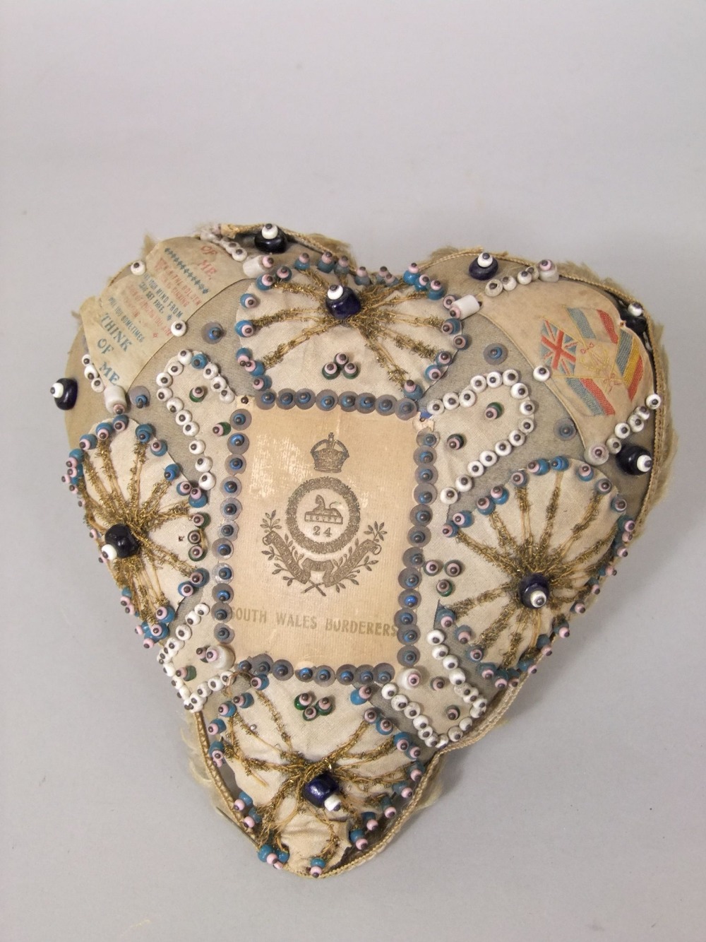 A WWI heart shaped sweetheart cushion with applied geometric bead work detail - South Wales