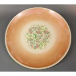 A Susie Cooper Dresden Spray pattern charger with peach ground finish and printed marks to