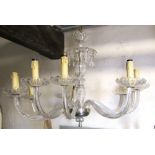 A ten branch chandelier, the moulded glass stem and branches supporting simulated sconces