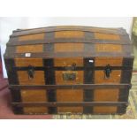 A late 19th century travelling trunk with domed lid, steel banded and timber lathe detail