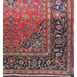Traditional Persian carpet, with typical scrolled foliage upon a red ground, 300 x 210 cm