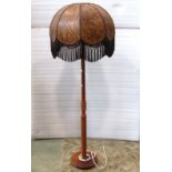 A mid 20th century teak standard lamp, with partially ring turned column and disc shade platform