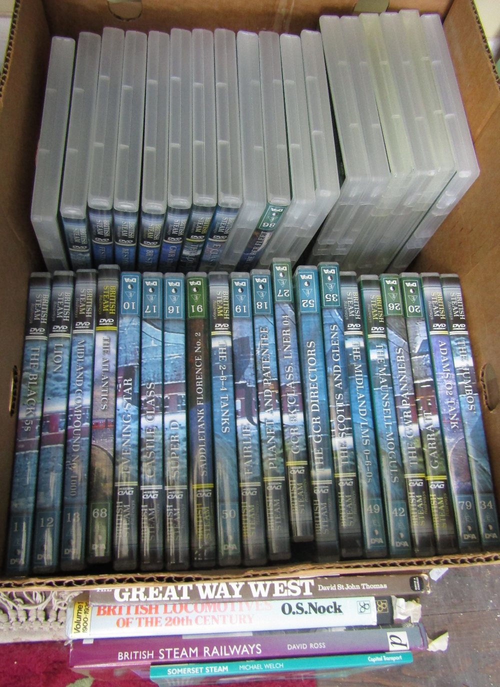A box containing a large number of railway related dvd's together with four train books
