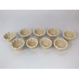 A set of seven small stoneware jelly moulds of circular form 9cm diameter approx, together with