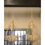 A pair of decorative ironwork hanging baskets with lattice detail and cream painted finish