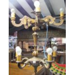 Two matched carved pine five branch chandeliers with scrolled arms and fluted columns