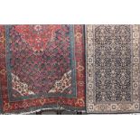 A Turkish rug with central red medallion and further geometric paisley motifs upon a blue ground,