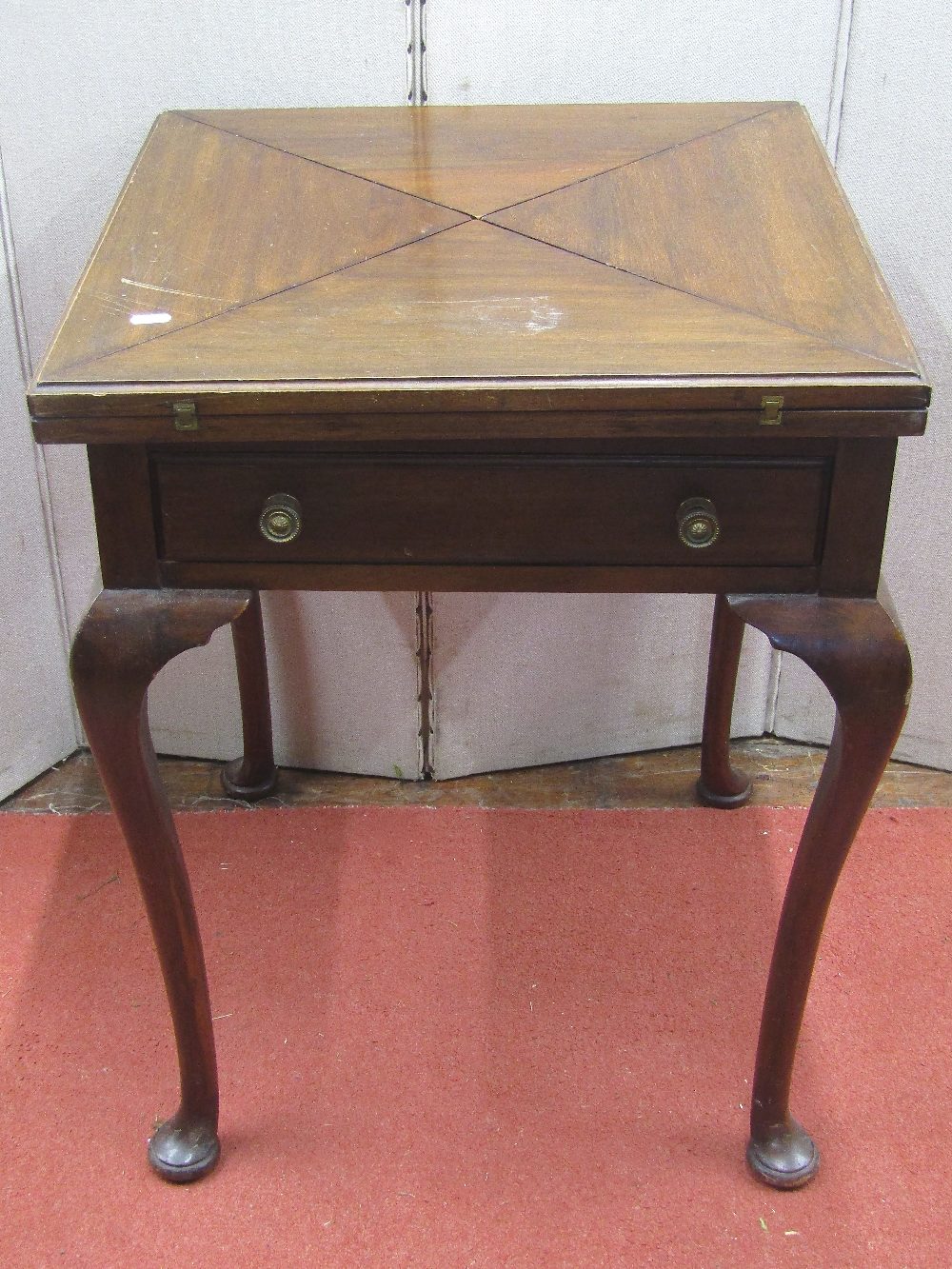 An Edwardian mahogany envelope card table or usual form on four pad feet