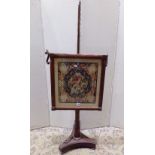 A Victorian rosewood pole screen supporting a square cut frame enclosing the original hand worked
