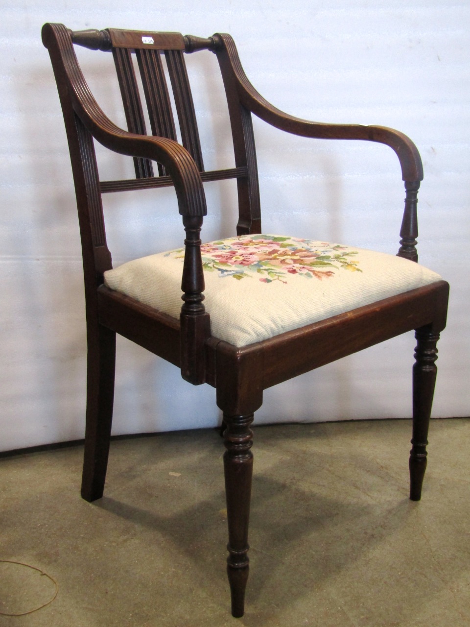 A Regency mahogany elbow chair with reeded frame and hand worked tapestry seat on turned supports