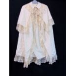 Late Victorian cape in ivory silk with collar and shoulder yoke, all edges trimmed with piping and