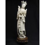 Large carved Chinese ivory figure of Guan Yin, wearing a flowing robe, holding chrysanthemum