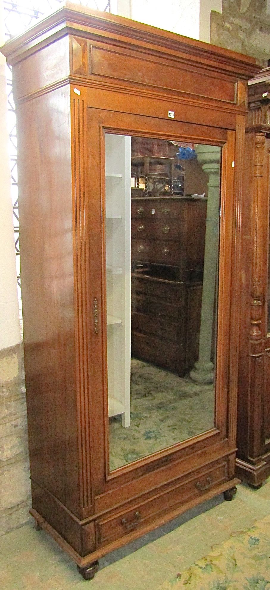 A 19th century continental walnut wardrobe enclosed by a single mirror panelled door, over a