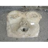 A carved stone gargoyle face mask (possibly early)