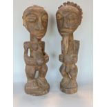 Tribal interest - pair of Hemba figures from the Congo, one figure with bird feathers attached to