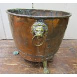 19th century copper cauldron with riveted panels, applied brass lions paw feet and lion mask