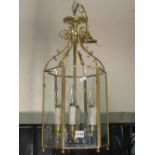 A Georgian style porch lantern of hexagonal form, the brass effect framework enclosing bevelled edge