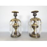 Pair of bronze and gilt metal lustre type candlesticks, with floral sconces and prismatic drops upon