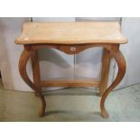 A stripped pine console table with pronounced cabriole forelegs, pair of painted table lamps,