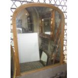 A Victorian style overmantel mirror, the moulded stripped pine and arched frame with carved