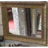 A 19th century arched and gilded overmantel mirror with applied and leaf moulded detail, together