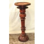 A carved hardwood torchere with shell and repeating detail