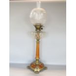 A good quality oak and cast brass art nouveau oil lamp, the glass shade and reservoir upon a tapered