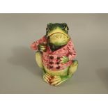 A late 19th century continental tobacco jar and cover in the form of a pipe smoking frog in a pink