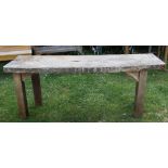 A rough mill sawn table with plank top raised on four square cut supports