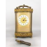 Brass and gilt brass cased serpentine carriage time piece with gilt mask and enamelled chapter