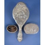 Three silver dressing set items to include a shaped silver hand mirror embossed with a family scene,